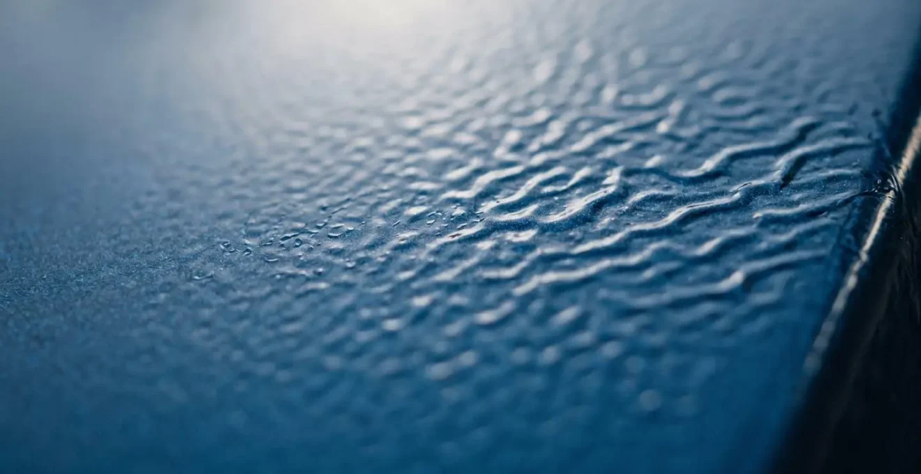 Gros plan macro sur une surface peinte présentant une texture de peau d'orange révélant les détails microscopiques du dépôt de peinture