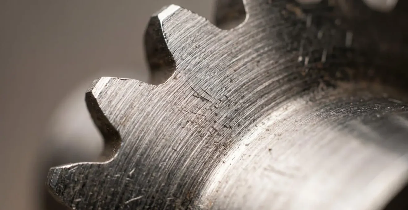 Gros plan macro d'une surface métallique brossée avec effets de lumière structurée révélant texture et micro-reliefs